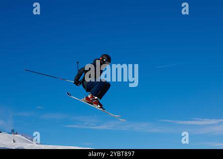 Sciatore che prende un po' d'aria dopo il lancio di un salto in un parco innevato Foto Stock