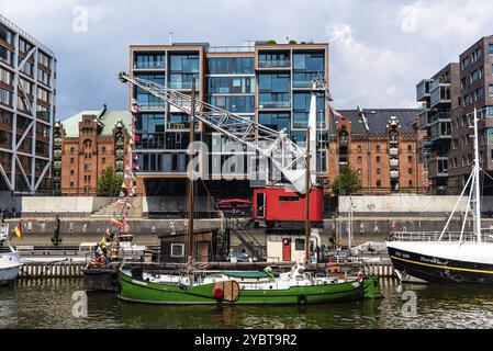 Amburgo, Germania, 7 agosto 2019: Paesaggio urbano del canale Sandtorhafen con navi ormeggiate sul porto e edifici residenziali moderni di lusso. Giornata di sole Foto Stock