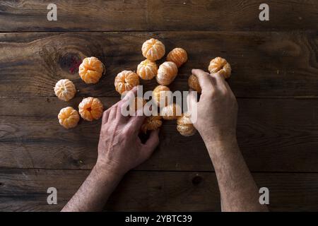 La presentazione di piccole pelate mandarini arance sul vecchio tavolo in legno Foto Stock