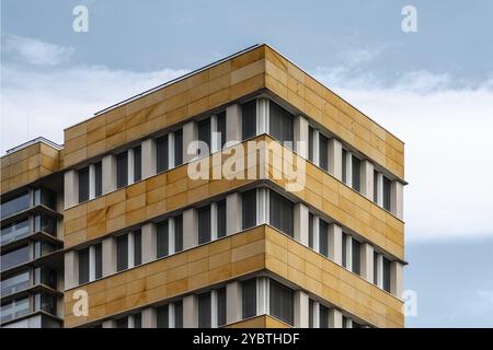 Berlino, Germania, 28 luglio 2019: Edificio di uffici dall'architettura moderna con facciata ventilata in pietra. Vista ad angolo basso contro il cielo, Europa Foto Stock