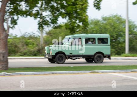 VARADERO, CUBA - 30 AGOSTO 2023: Green Land Rover Defender 110 3 porte a Cuba, pieno di persone, effetto di sfocatura del movimento Foto Stock