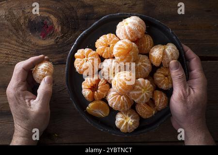 La presentazione di piccole pelate mandarini arance sul vecchio tavolo in legno Foto Stock