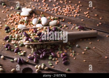 Legumi di seme mescolati in un cucchiaio su vecchio tavolo di legno Foto Stock