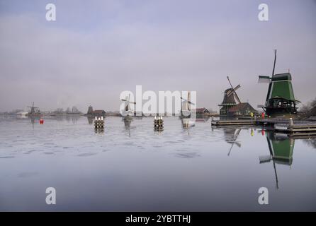 Mulini a vento lungo il fiume Zaan nel villaggio tradizionale olandese Zaanse Schans, una delle località turistiche più trafficate nei Paesi Bassi Foto Stock