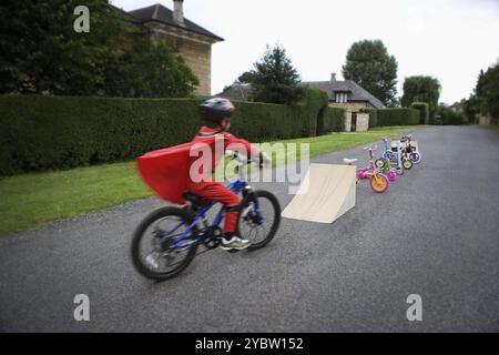 Giovane ragazzo in Bicicletta Equitazione verso la rampa Foto Stock