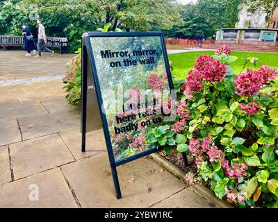 Un cartello a specchio legge lo specchio sulla lettiera sinistra qui si riflette male su tutti noi nel giardino della St. Paul's Churchyard presso la St. pauls Cathedral London EC4M 8AD; messaggio anti-lettiera tra le aiuole dei fiori pianificate Foto Stock