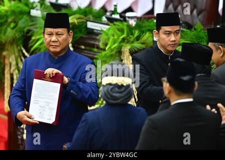 Giacarta, Indonesia. 20 ottobre 2024. Il presidente indonesiano Prabowo Subianto (1° L) e il vicepresidente Gibran Rakabuming Raka (3° L) partecipano alla cerimonia di inaugurazione presidenziale presso l'edificio del parlamento a Giacarta, Indonesia, 20 ottobre 2024. L'ex generale dell'esercito indonesiano, Prabowo Subianto, ha prestato giuramento come ottavo presidente del paese domenica mattina presso l'edificio del parlamento, succedendo a Joko Widodo, che ha guidato la quarta nazione più popolosa del mondo negli ultimi dieci anni. Crediti: Rivan Awal Lingga/Xinhua/Alamy Live News Foto Stock