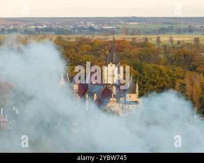 Riprese aeree del drone del castello di Moszna, Polonia, viste mozzafiato della maestosa architettura neogotica e barocca, circondate da lussureggianti giardini e panorami Foto Stock