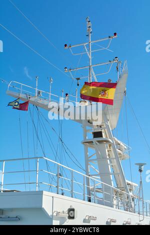 Barcellona. Espain -20 ottobre 2024: Primo piano di una struttura della nave con una bandiera spagnola sventolata contro un cielo azzurro. Ideale per argomenti correlati Foto Stock