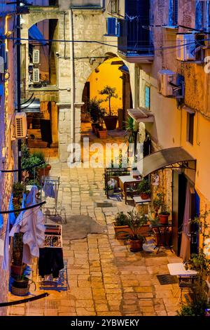 Scena notturna di un vicolo a Bari Vecchia, illuminato da luci calde e fresche. Italia. Foto Stock