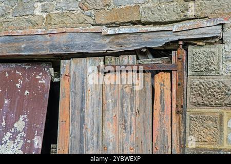 Una vecchia e malconcia porta fienile appesa alle sue cerniere arrugginite nel Derbyshire, in Inghilterra Foto Stock