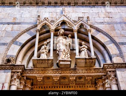 La lunetta sulla facciata della Chiesa di San Michele in Borgo, Pisa, presenta un'edicola gotica con una statua della Madonna con bambino Foto Stock