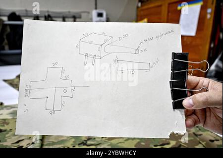 Non esclusivo: ZAPORIZHZHIA, UCRAINA - 17 OTTOBRE 2024 - Una persona tiene il disegno del protettore per la mitragliatrice durante la dimostrazione di Foto Stock