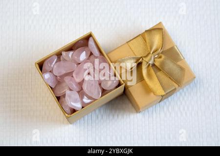 Diversi pezzi di quarzo rosa lucido su sfondo testurizzato. Vista dall'alto minima della fotografia STILL Life a colori Foto Stock