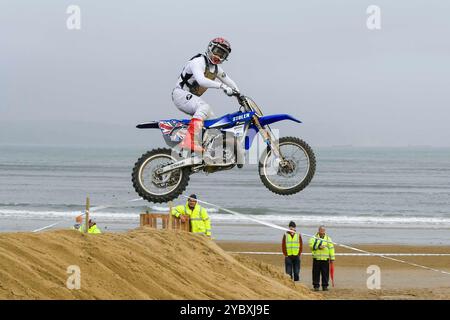 Weymouth, Dorset, Regno Unito. 20 ottobre 2024. Oltre trecento piloti osservati da migliaia di spettatori partecipano alla 40a gara di motocross di Weymouth Beach su un percorso improvvisato scavato dalla sabbia dorata del resort da scavatori. L'evento gratuito annuale è gestito dal Purbeck Motocross Club. I piloti esperti prendono un po' d'aria dal primo salto. Crediti fotografici: Graham Hunt/Alamy Live News Foto Stock