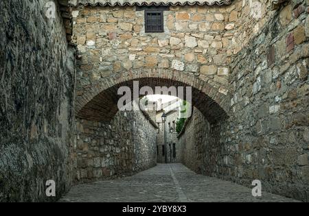 Vicolo nella città vecchia di Baeza a Jaén, Andalusia, Spagna, una città Patrimonio dell'Umanità, con un arco che attraversa da un lato all'altro un vicolo Foto Stock