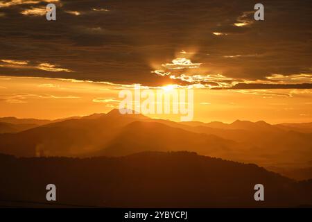 paesaggio di un tramonto sulle montagne, caldi colori arancioni con una caduta molto speciale sulle montagne Foto Stock