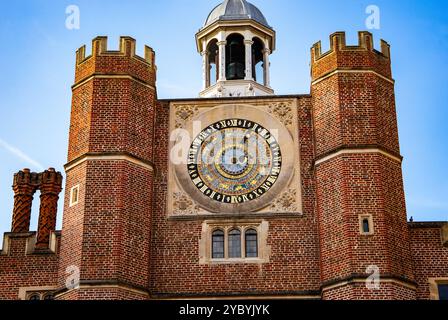 Storica torre dell'orologio astronomico dal design intricato caratterizzato da pareti in mattoni rossi ed elementi architettonici medievali dell'Hampton Court Palace Foto Stock