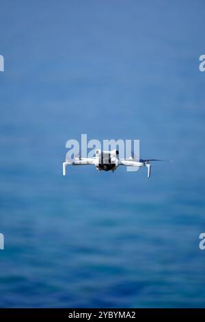 Mini drone che vola sul mare in una giornata estiva di sole, DJI mini pro 4 Foto Stock