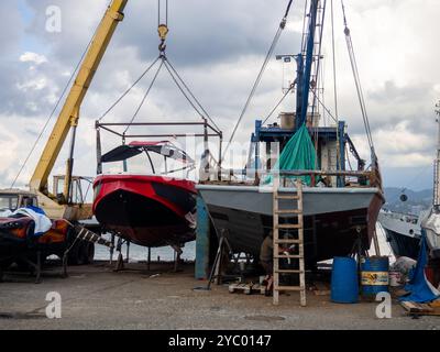 Le navi sono sospese per riparazioni nel molo. Le vecchie barche sono in fase di riparazione. Banchine al lavoro. Ripristino del fondo delle navi. Foto Stock