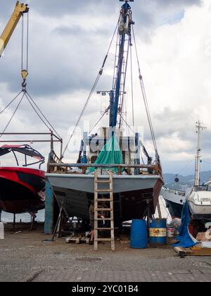 Le navi sono sospese per riparazioni nel molo. Le vecchie barche sono in fase di riparazione. Banchine al lavoro. Ripristino del fondo delle navi. Foto Stock