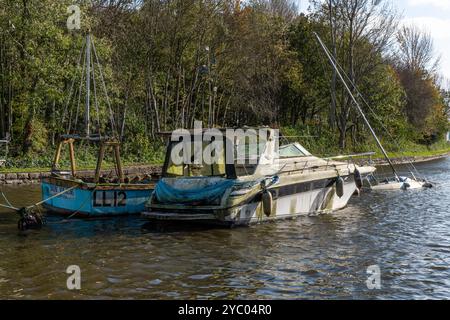 Barche abbandonate e danneggiate su un canale. Foto Stock