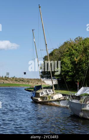 Barche abbandonate e danneggiate su un canale. Foto Stock