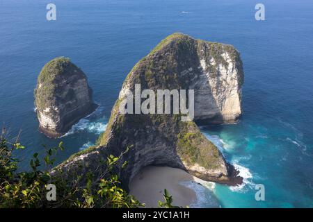 Dall'alto, le onde turchesi si infrangono dolcemente sulle morbide sabbie di Kelingking Beach a Nusa Penida, Bali. I colori brillanti mostrano la bellezza e la Foto Stock