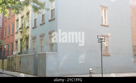 Incrocio a New York City, incrocio con Minetta Street, cartello con la freccia a senso unico. Edificio residenziale Manhattan Greenwich Village, New York, Stati Uniti. Muro di mattoni blu, idrante di fuoco. Foto Stock