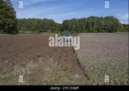 Agricoltore con trattore arato il suo campo con un aratro rotante a 5 giri, Franconia, Baviera, Germania, Europa Foto Stock