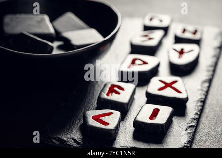 Primo piano della vecchia divinazione con pietre di rune nere basate sull'antico alfabeto di futhark Foto Stock