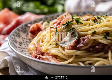 Spaghetti tradizionali italiani con prosciutto, funghi e parmigiano. Foto Stock