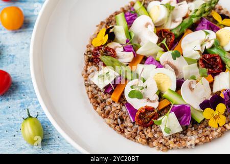 Insalata di quinoa con funghi, uova e pomodori secchi serviti su un piatto di porcellana bianca Foto Stock
