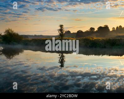 Alba su un bel tratto del fiume Tamigi presso Radley Boathouse. Fondata nel 1921, la Boathouse serve da oltre un secolo il Radley College e gli appassionati di canottaggio locali. Se ti trovi sul suo molo e guardi dall'altra parte della riva nord del fiume, vedrai questo albero isolato e piuttosto grazioso, che sembra cambiare carattere e aspetto durante tutto l'anno. Può essere particolarmente bello all'alba - come qui. Foto Stock