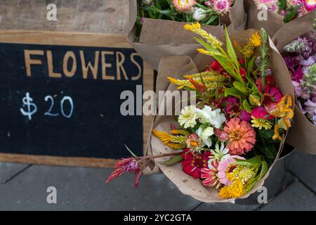 Mazzi di fiori colorati in vendita presso uno stand del mercato agricolo Foto Stock