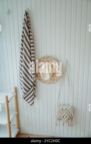 Telo da mare, cappello di paglia e borsa in macramé in una casa sulla spiaggia danese Foto Stock