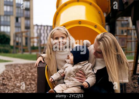 Mamma passa del tempo con i bambini al parco giochi Foto Stock