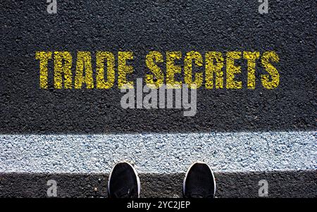 Messaggio segreto commerciale scritto su strada asfaltata. Simbolo dei segreti commerciali concettuali. Copia spazio. Foto Stock
