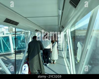 Passeggeri all'interno del ponte d'imbarco, vista dal retro delle persone che entrano in Qatar Air Aircraft Foto Stock