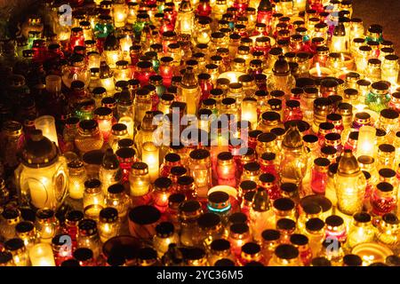 i colorati vasi di candele risplendono calorosamente al cimitero in tutti i santi del giorno Foto Stock