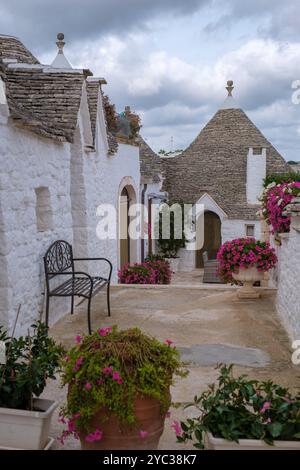 Alberobello immerso nel cuore della Puglia, le tradizionali case dei trulli mostrano i loro unici tetti conici contro un cielo coperto. Foto Stock