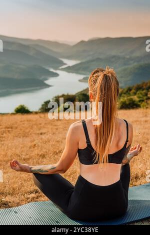 Donna di yoga in meditazione seduta in posa di loto Foto Stock