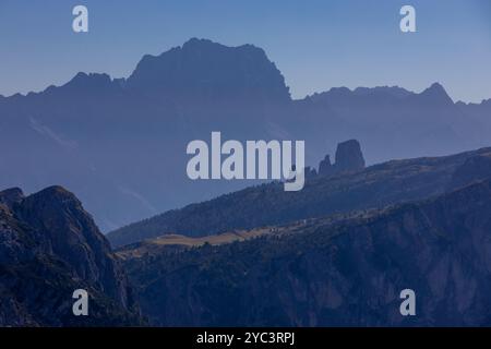 Cielo nebbioso con nuvole e profili montani nella nebbia in autunno. Orizzonte cielo con alte cime montuose che si stagliano nelle Alpi dolomitiche nel blu Foto Stock