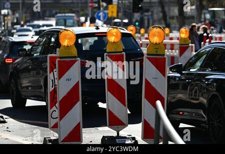 PRODUZIONE - 21 ottobre 2024, Assia, Francoforte sul meno: Segnalatori luminosi con luci lampeggianti guidano il traffico in un cantiere della stazione ferroviaria locale nel quartiere di Sachsenhausen. Concedi più tempo durante la guida attraverso le città dell'Assia. Ciò è dovuto al fatto che i lavori stradali vengono svolti in molti luoghi. L'arretrato dei lavori di ristrutturazione è lungo e non verrà risolto rapidamente. Foto: Arne Dedert/dpa Foto Stock