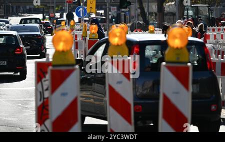 PRODUZIONE - 21 ottobre 2024, Assia, Francoforte sul meno: Segnalatori luminosi con luci lampeggianti guidano il traffico in un cantiere della stazione ferroviaria locale nel quartiere di Sachsenhausen. Concedi più tempo durante la guida attraverso le città dell'Assia. Ciò è dovuto al fatto che i lavori stradali vengono svolti in molti luoghi. L'arretrato dei lavori di ristrutturazione è lungo e non verrà risolto rapidamente. Foto: Arne Dedert/dpa Foto Stock