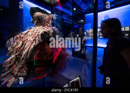 Londra, Regno Unito. 21 ottobre 2024. Un membro del personale vedrà "Alice's Red dress", 2010, del costumista Colleen Atwood per il film "Alice nel paese delle meraviglie", 2020, in anteprima alla mostra World of Tim Burton al Design Museum. Conosciuto principalmente per il suo lavoro cinematografico, Tim Burton è anche un artista multidisciplinare. 600 oggetti dei suoi archivi personali, che coprono 50 anni, sono esposti per la prima volta nel Regno Unito, dal 25 ottobre 2024 al 21 aprile 2025. Crediti: Stephen Chung / Alamy Live News Foto Stock