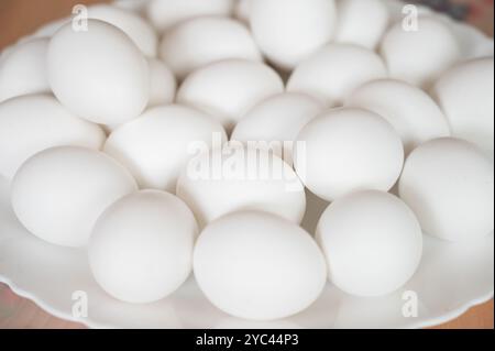 Foto a tema pasquale con uova bianche su un piatto bianco Foto Stock