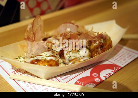 Takoyaki in stile giapponese su un piatto con bacchette Foto Stock