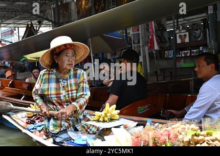 "Mercato galleggiante Thailandia" Ritratto di una donna anziana in Thailandia che vende frutta in barca attraverso il canale affollato del damneon saduak Thailand Bangkok Foto Stock