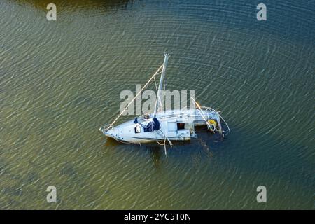 Vista aerea della barca a vela sommersa sulle acque poco profonde della baia dopo l'uragano a Manasota, Florida. Foto Stock